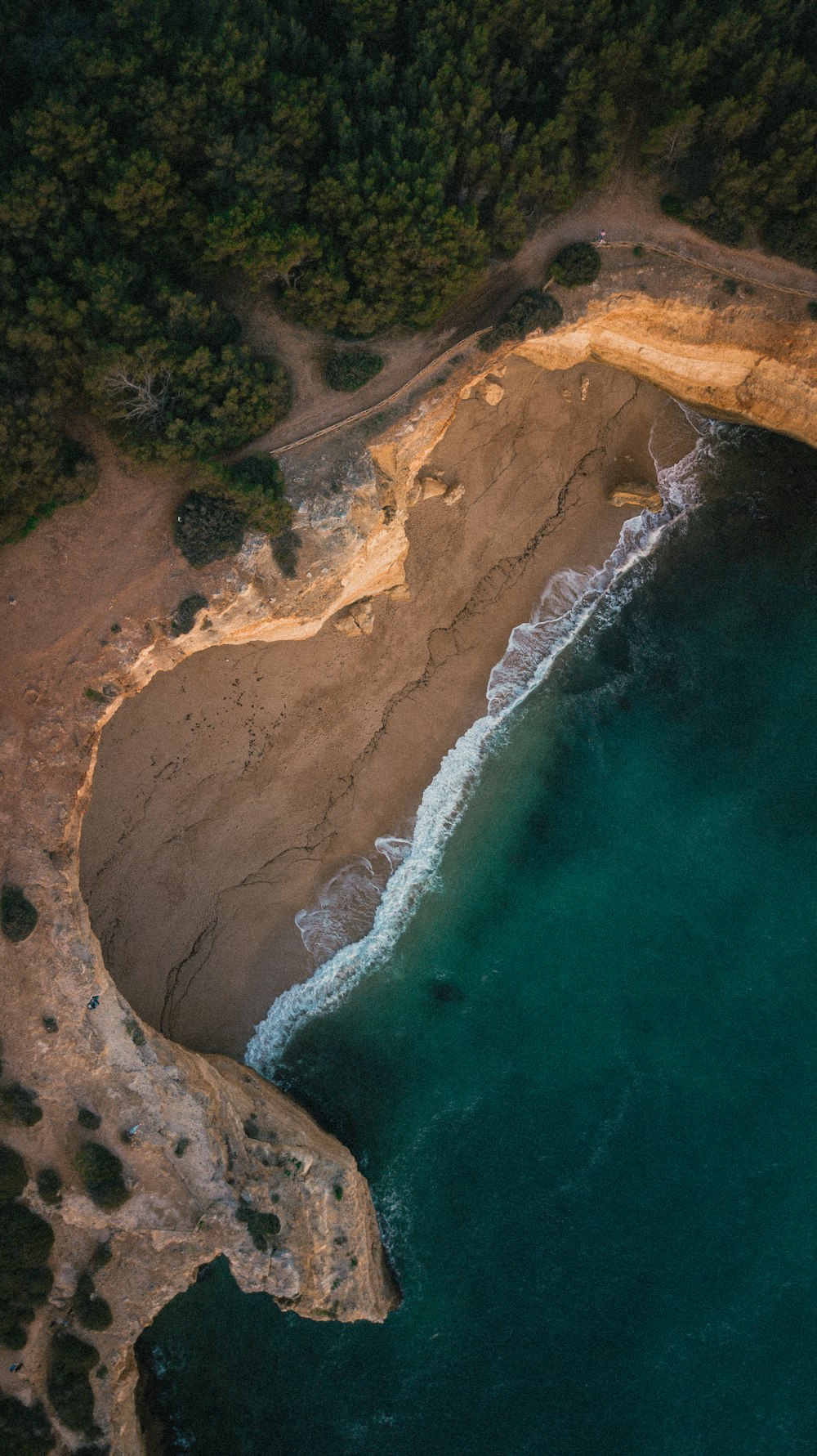 an aerial view of a body of water next to a cliff