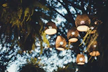 A twilight-lit workshop nestled among ancient trees, with glowing lanterns hanging from branches.