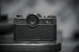 A vintage film camera resting on a wooden table, symbolizing storytelling craft.