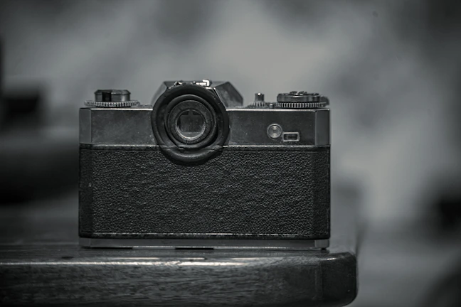 A vintage film camera resting on a wooden table, symbolizing storytelling craft.