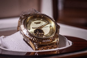 a gold watch sitting on top of a white shoe