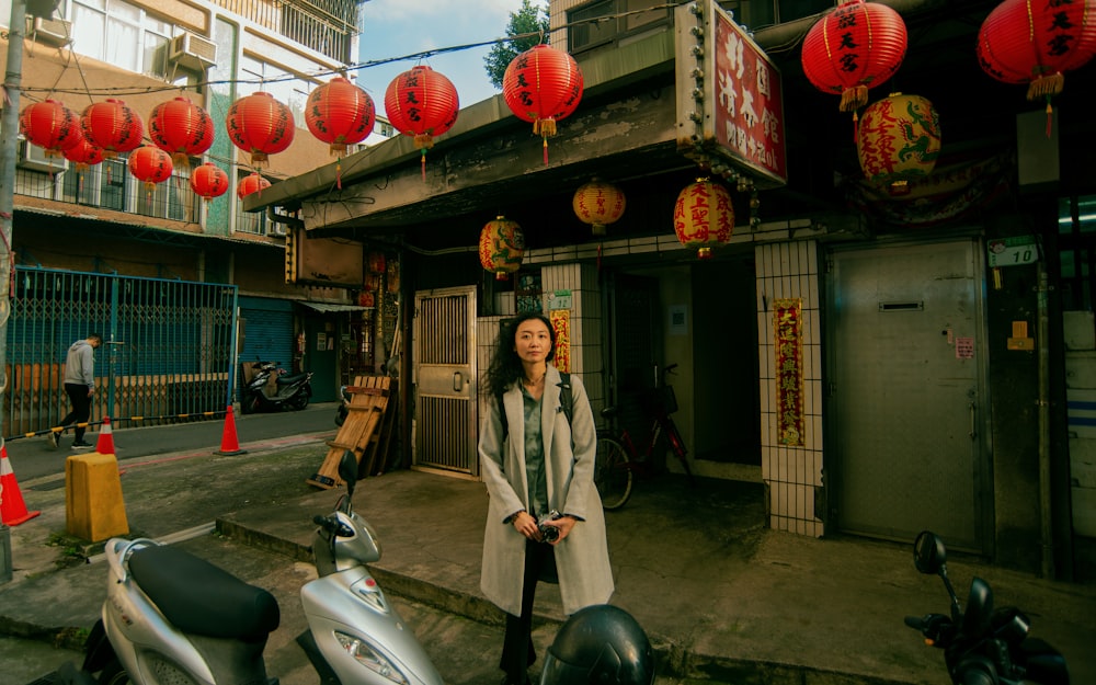 a woman standing in front of a building with red lanterns