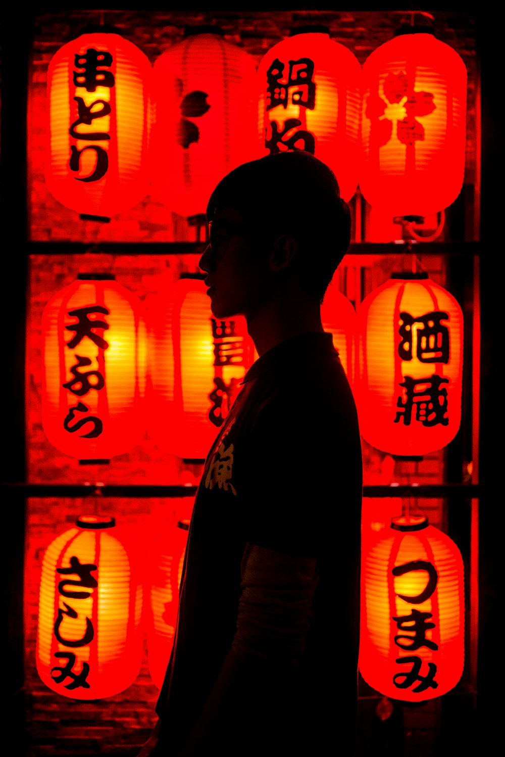 a man standing in front of a display of red lanterns