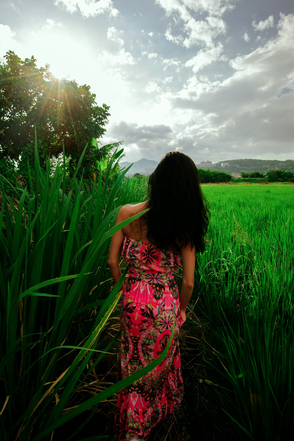 a woman in a pink dress standing in a field