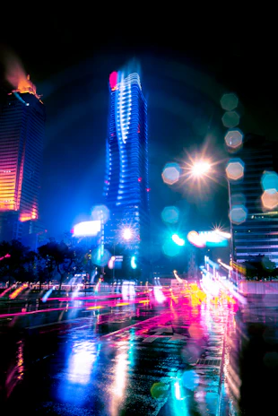 A vibrant cityscape at dusk with neon lights reflecting off wet streets, capturing the pulse of modern urban life.