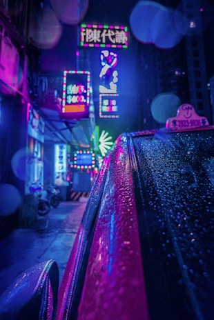 A neon-lit street scene showcasing a model in sleek techwear with glowing accents under a rainy cyberpunk cityscape.