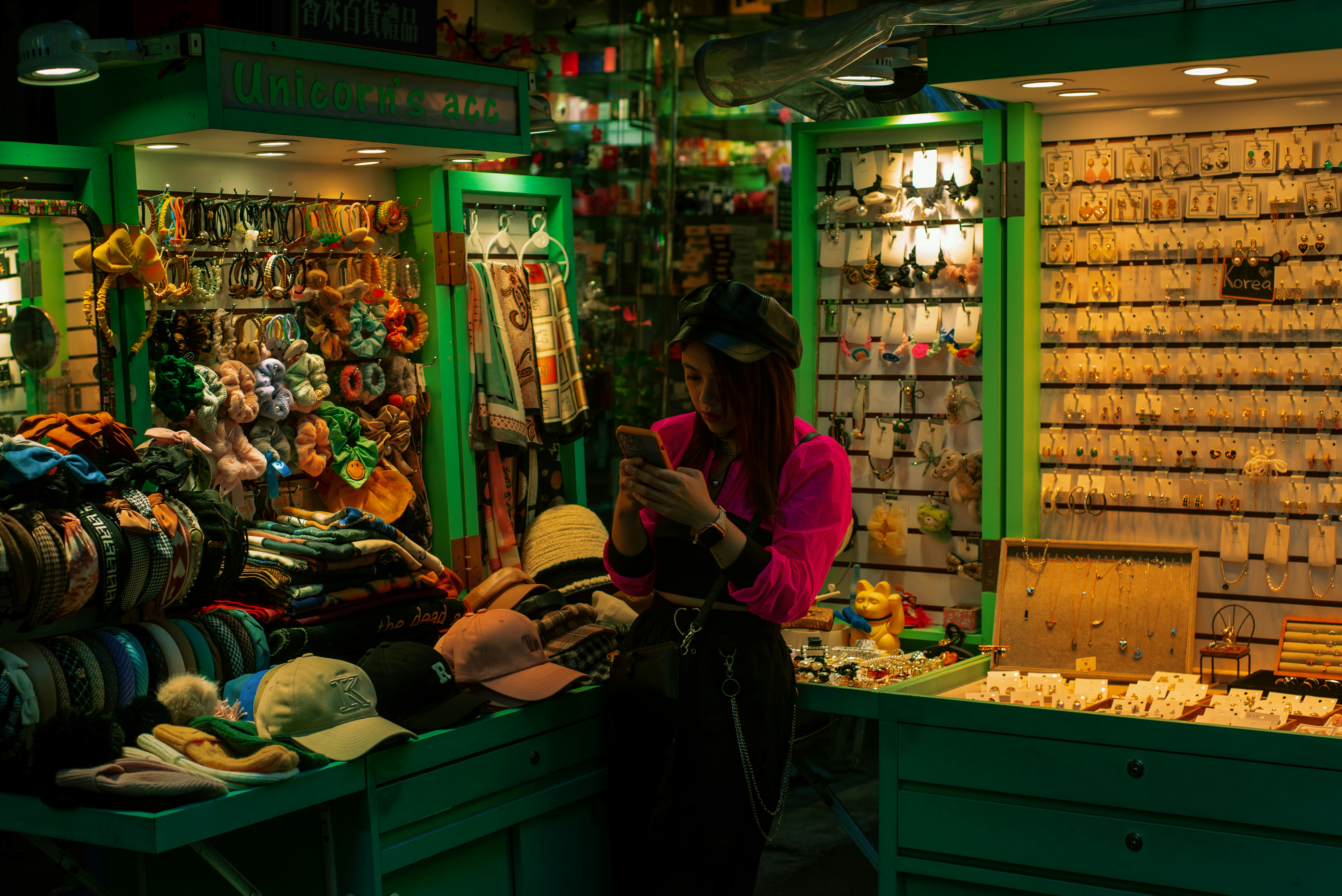 a woman standing in front of a store looking at a cell phone