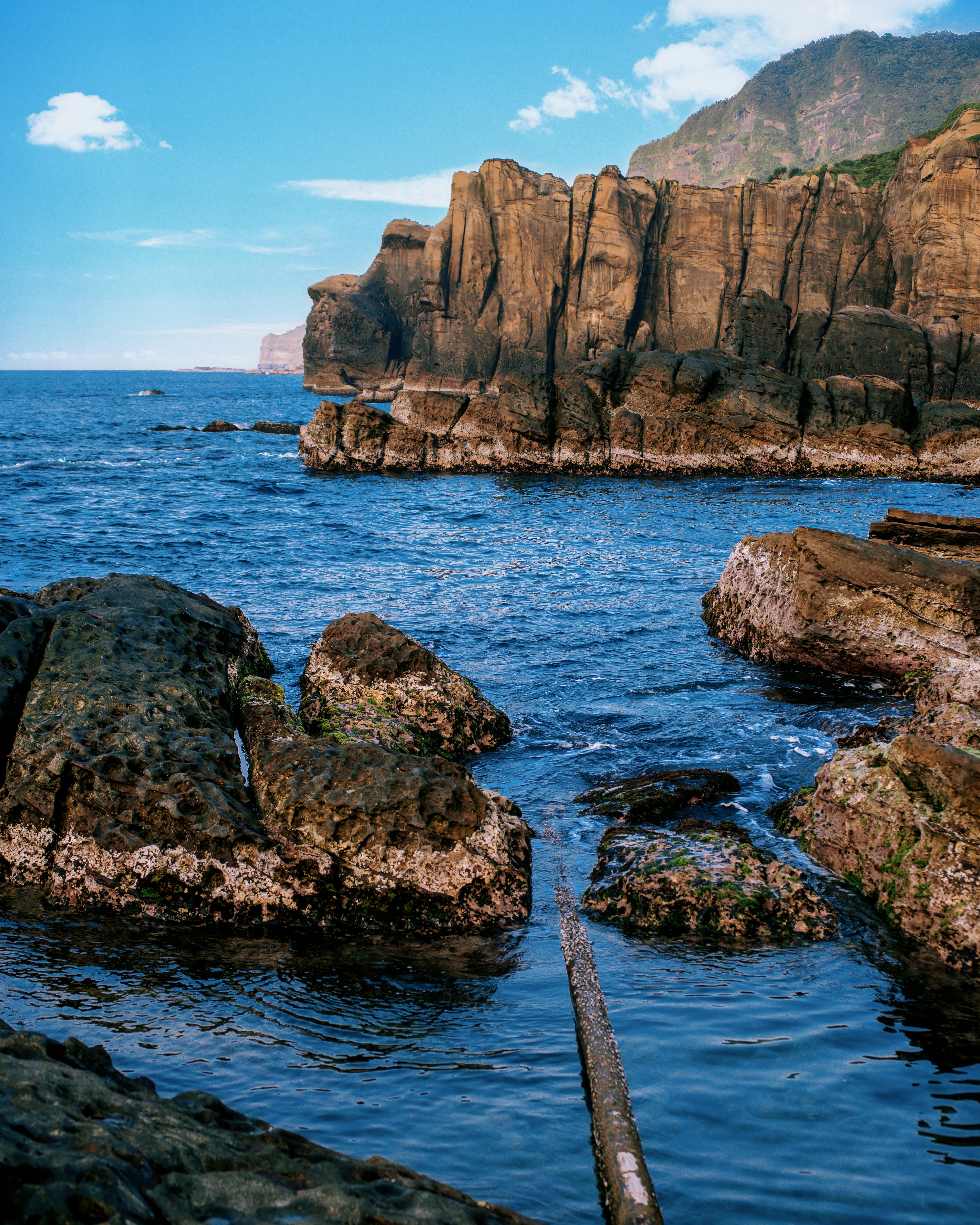 A large body of water surrounded by rocks photo – Free Nature Image on ...