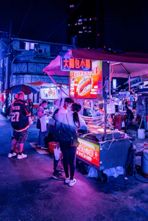 A bustling night market scene with neon signs and food stalls serving local favorites