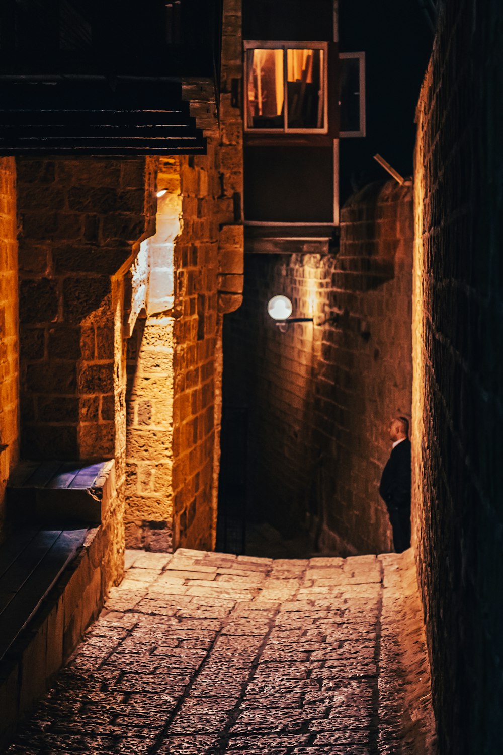 a person standing in an alley way at night