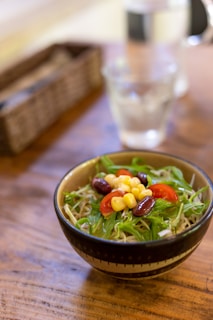 Fresh colorful salad bowl with mixed greens and vegetables on a wooden table