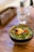 A fresh bowl of colorful mixed salad with various vegetables on a wooden table.