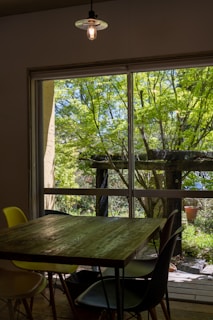 Wide view of a custom wooden dining table set in a bright, inviting space.