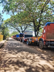 A fleet of various trucks lined up ready for dispatch on a sunny day.