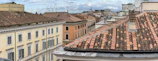 A panoramic view of London’s skyline from a hidden rooftop terrace framed by old chimneys.