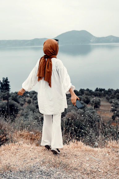 a person standing on a hill overlooking a body of water