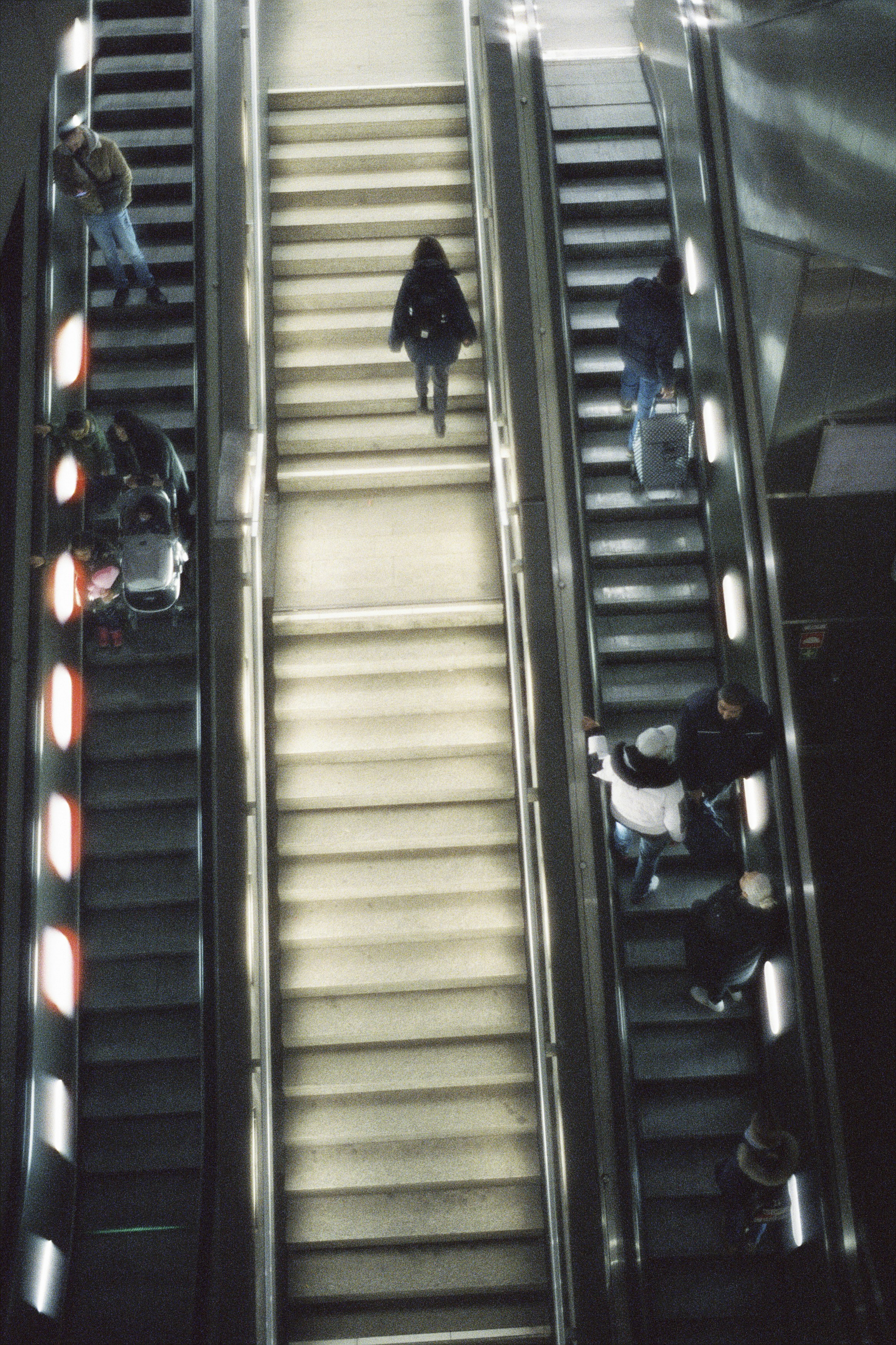 a group of people riding down an escalator