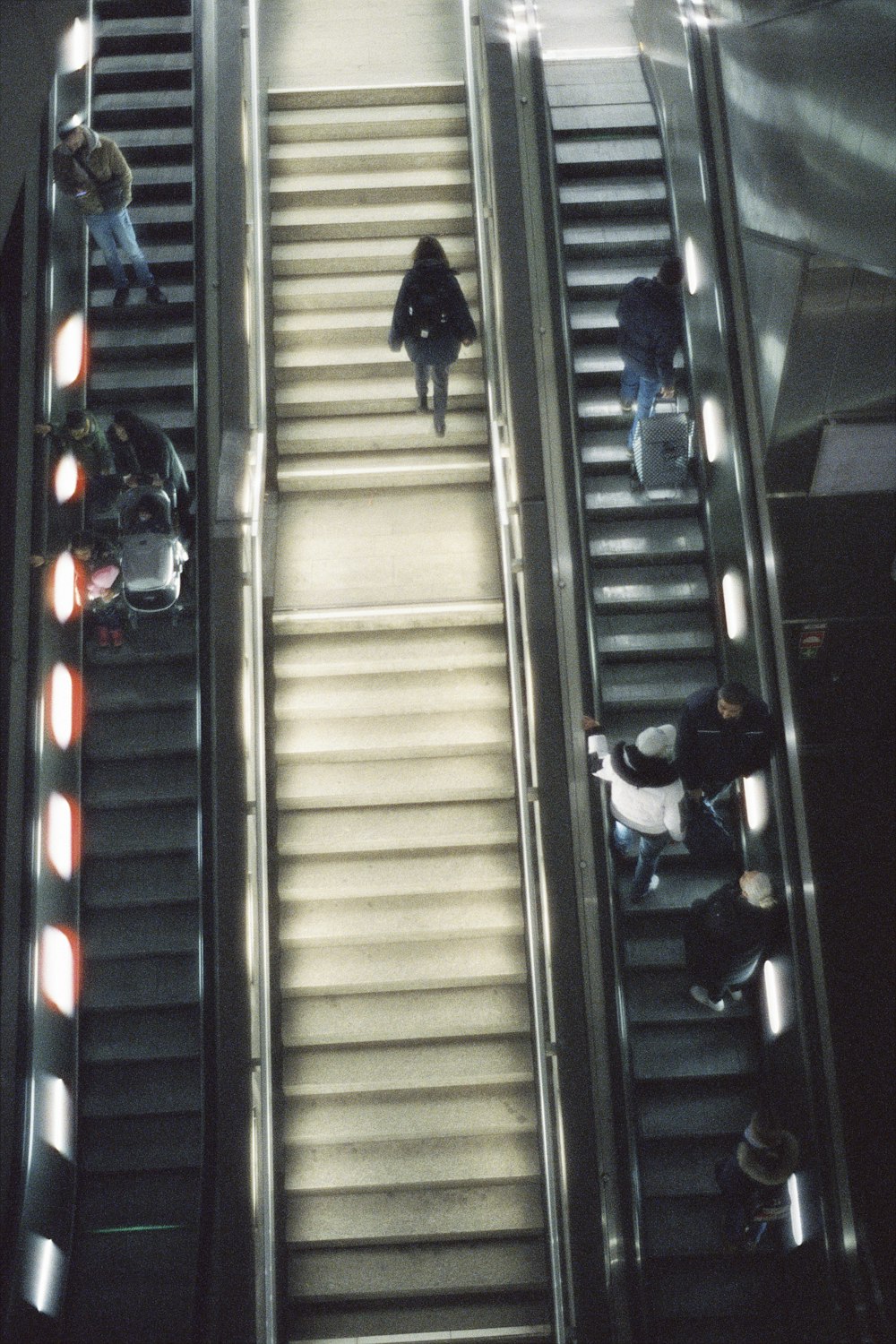 a group of people riding down an escalator