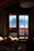 Cozy rustic bedroom with soft lighting and a window showing a mountain view.