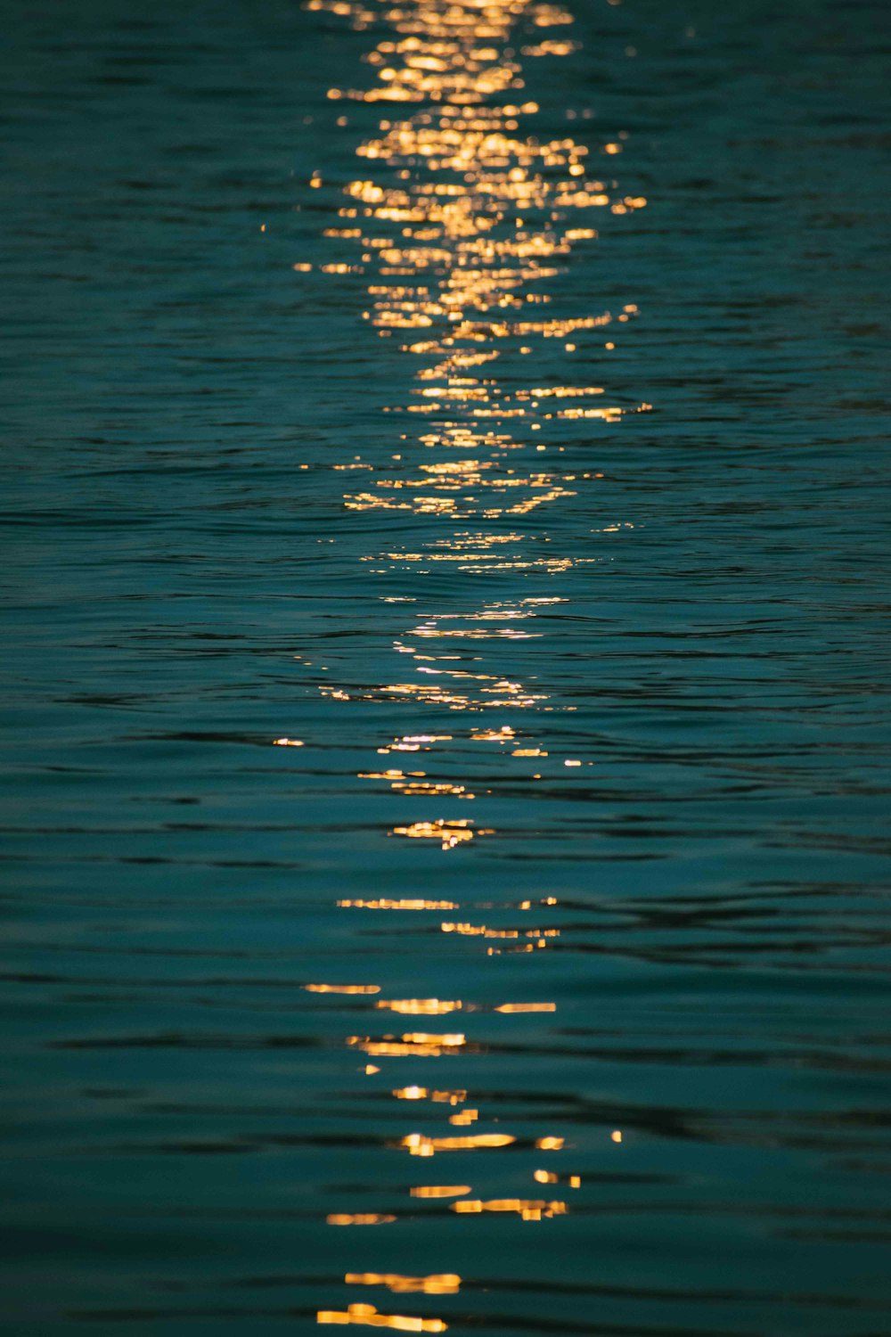 a long line of water with the sun reflecting off of the water