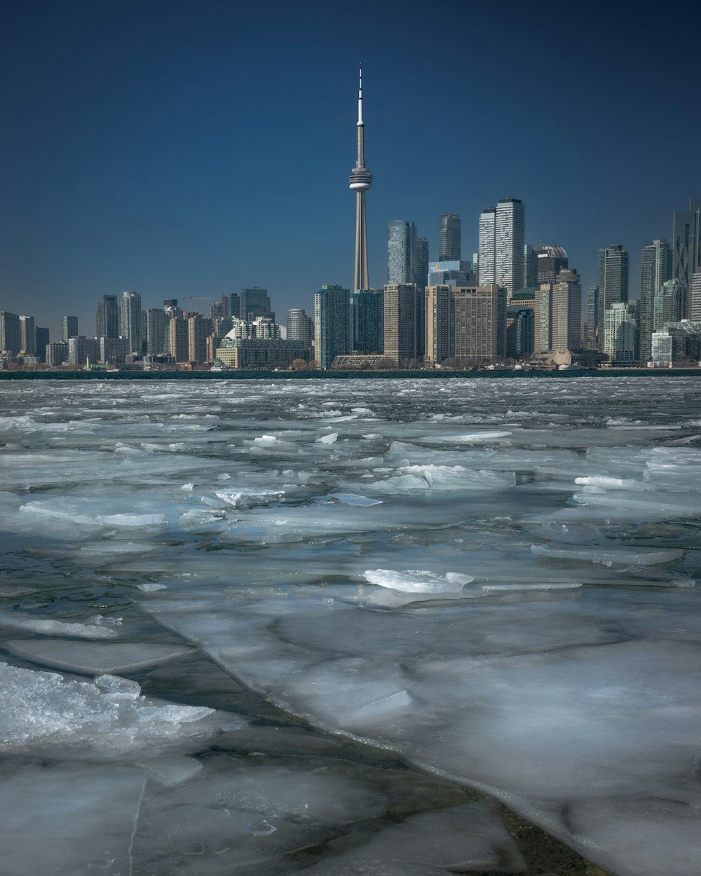 a large body of ice with a city in the background