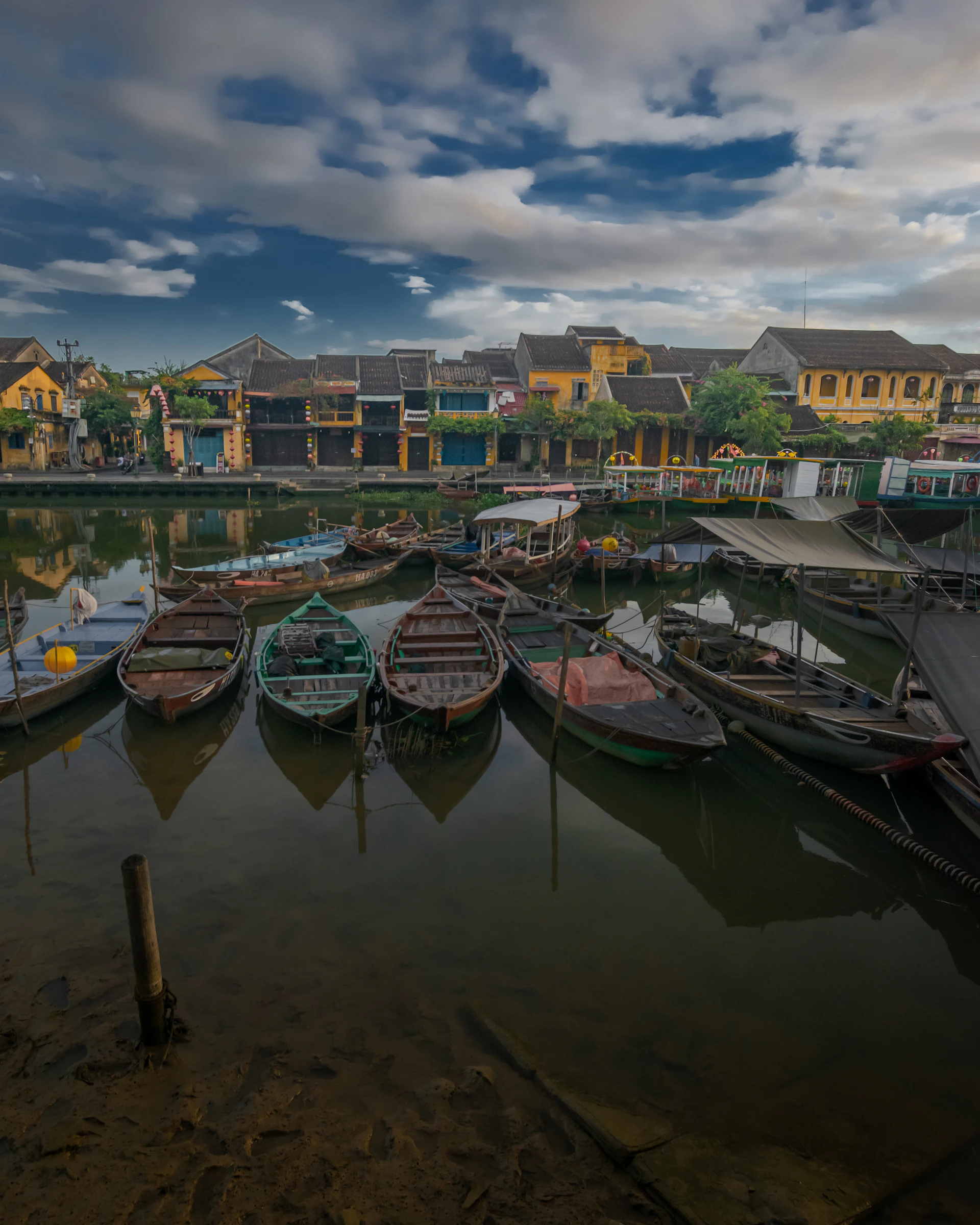 a harbor filled with lots of boats under a cloudy sky