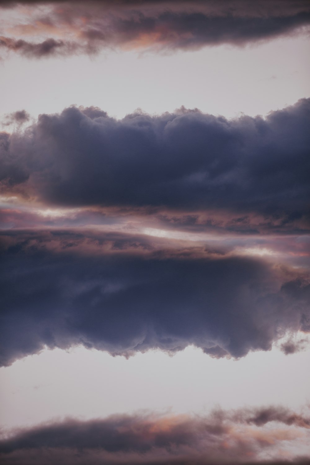 a plane flying through a cloudy blue sky