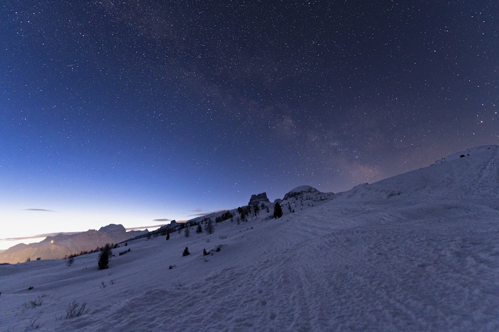 a night sky with stars above a snowy mountain