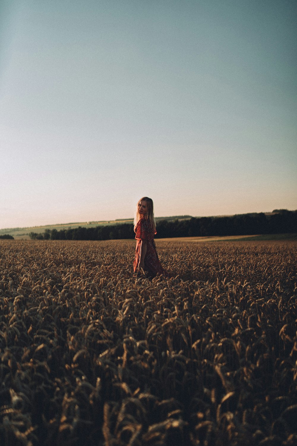 a little girl standing in the middle of a field