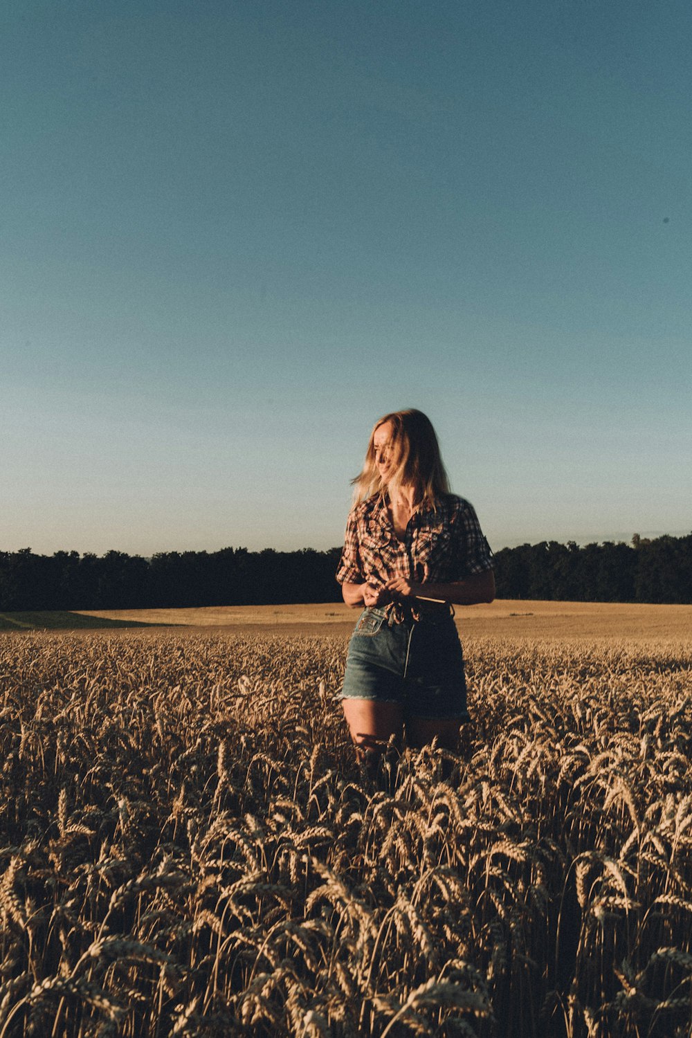 a woman standing in a field of wheat