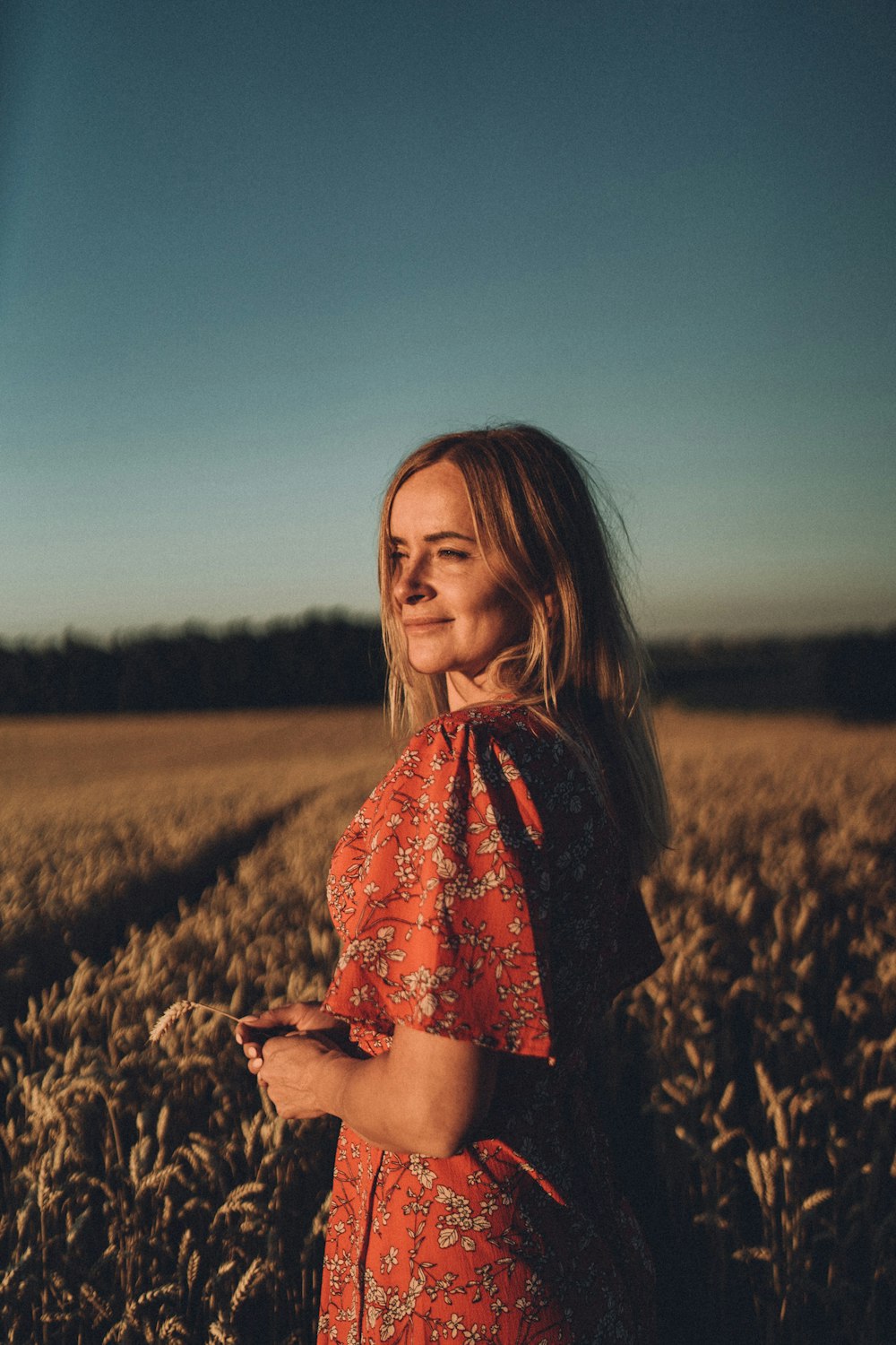 a woman in a red dress standing in a field