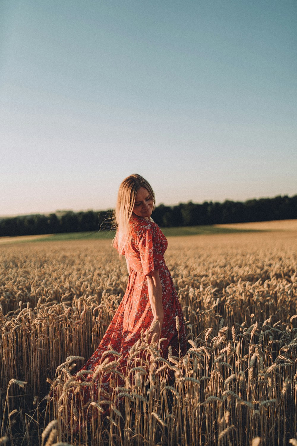 a woman standing in a field of wheat