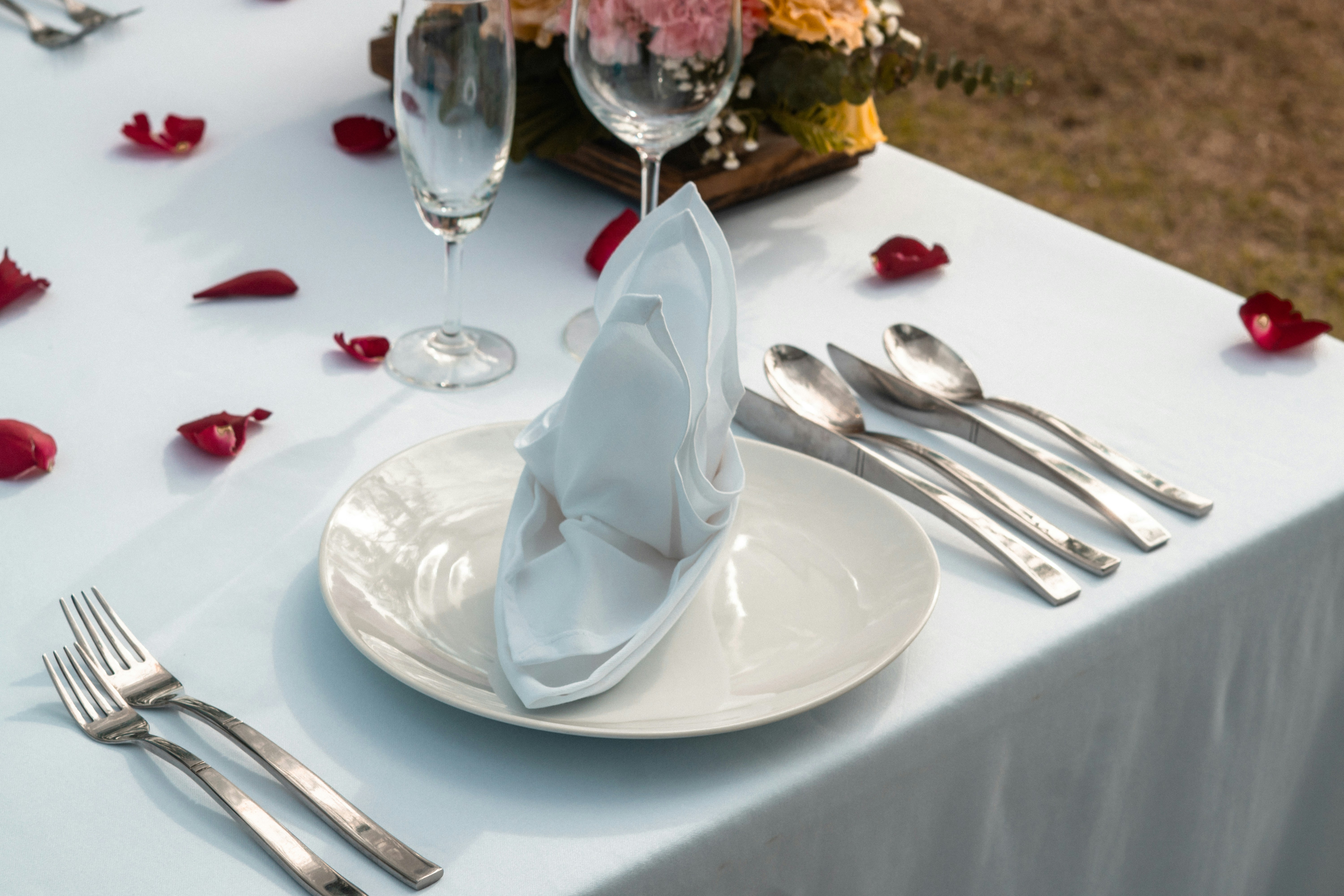 a table with a white table cloth and silverware
