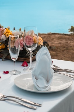 two glasses of wine on a table with flowers