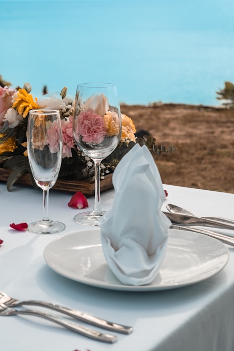 two glasses of wine on a table with flowers