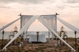 An intimate dinner setup on a private beach under twinkling lanterns.