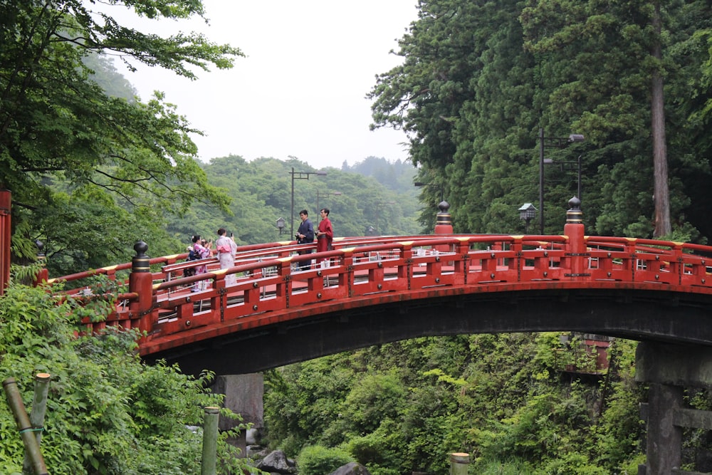 a red bridge with people walking across it