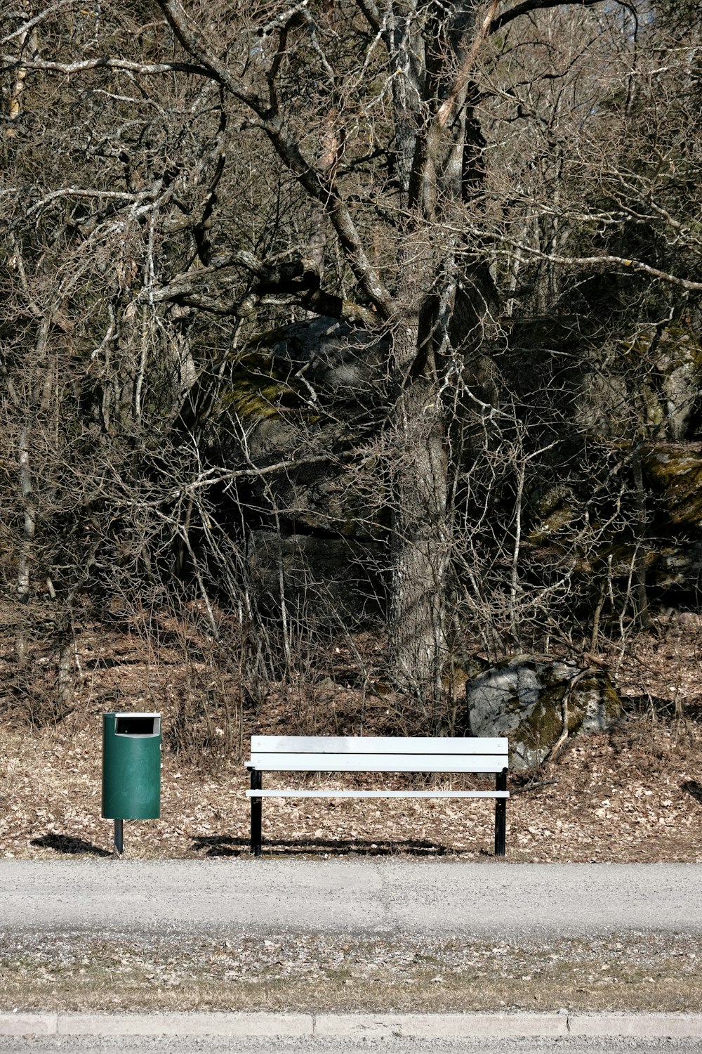 a white bench sitting on the side of a road