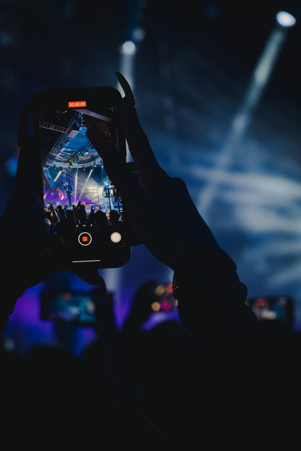 a person taking a picture of a concert with a cell phone