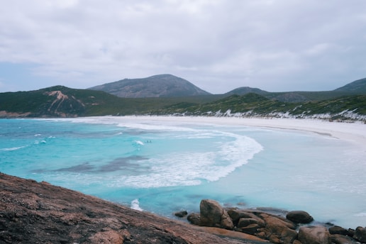 a view of a beach from a rocky cliff