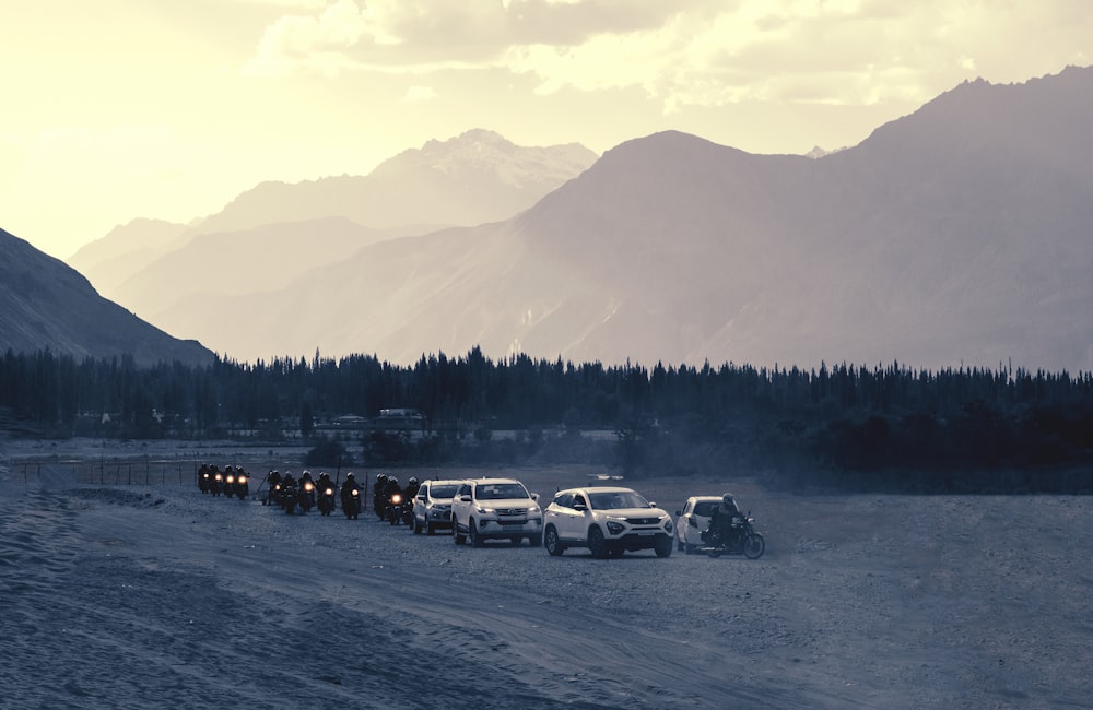 uma fila de caminhões dirigindo por uma estrada de terra