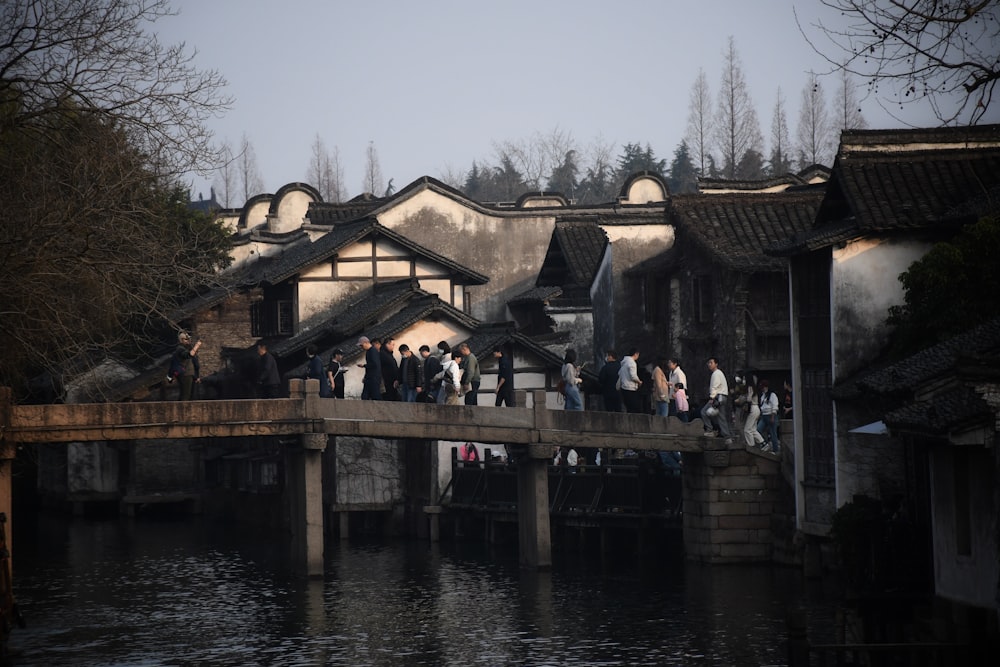 a group of people standing on a bridge over a body of water