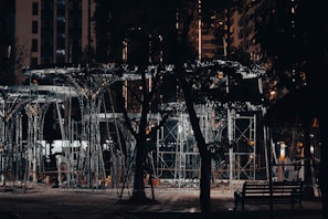 Night view of a construction site illuminated by strong industrial lights showcasing metal structures