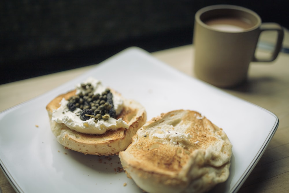 a white plate topped with a sandwich and a cup of coffee