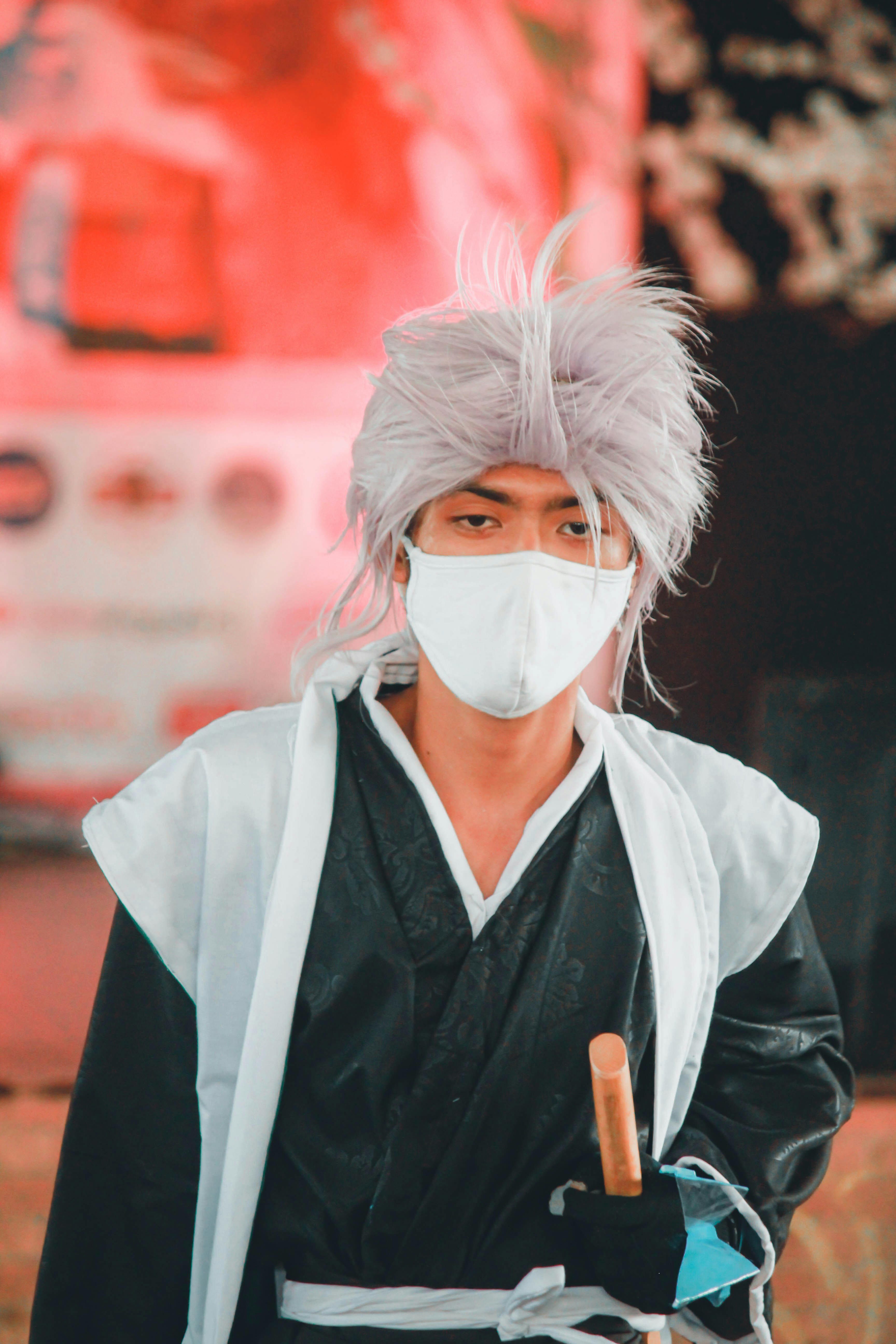 a man wearing a mask and holding a cigarette