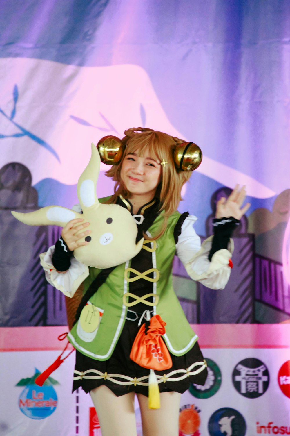 a woman holding a stuffed animal on top of a stage