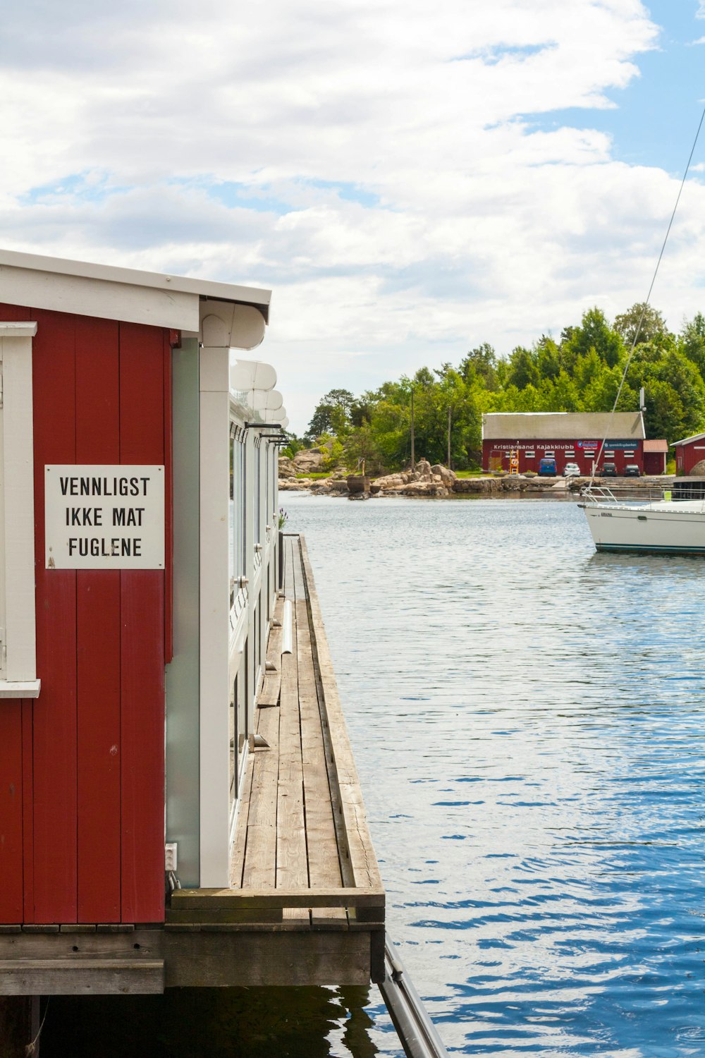 a boat is docked at a dock near a red building