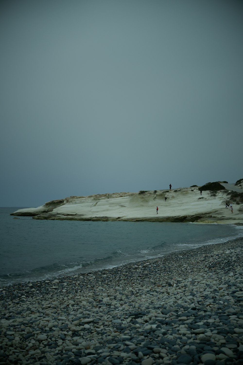 a group of people standing on top of a sandy beach