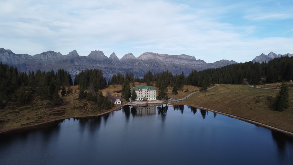 a house on a lake surrounded by mountains