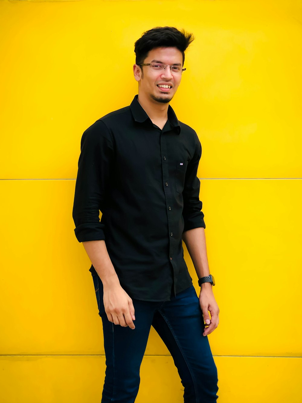 a man standing in front of a yellow wall